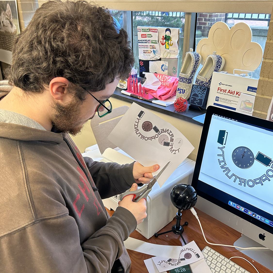 Student cutting paper graphics in Maker Commons